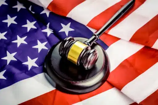 A judge's gavel sitting on a partially folded American flag